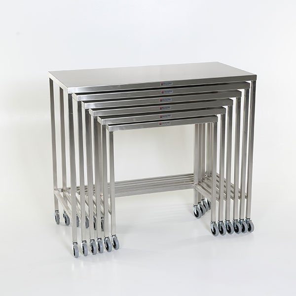 A set of four stainless steel tables with wheels.