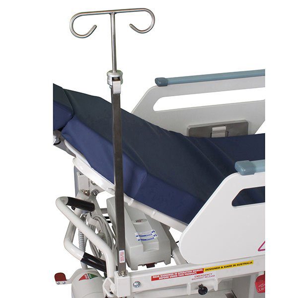 A hospital bed with a blue cover and a white frame.