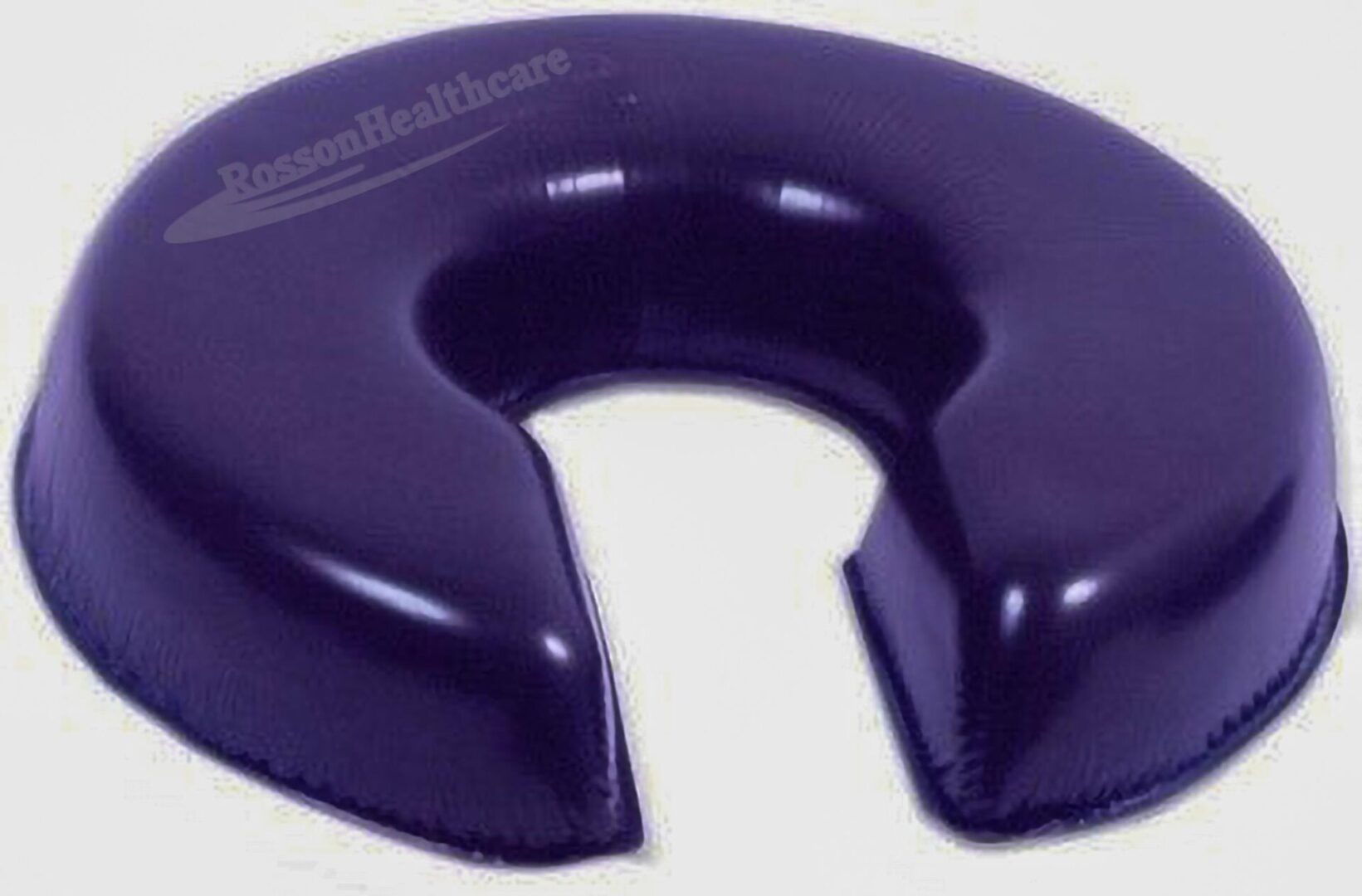 A purple pillow that is shaped like a horseshoe.